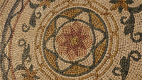 Intricate mosaic design featuring a floral pattern in earthy tones — handcrafted tiles create a stunning visual texture.
