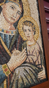 Intricate mosaic art depicting a mother and child in warm earthy tones — handcrafted tiles create a textured, vibrant finish