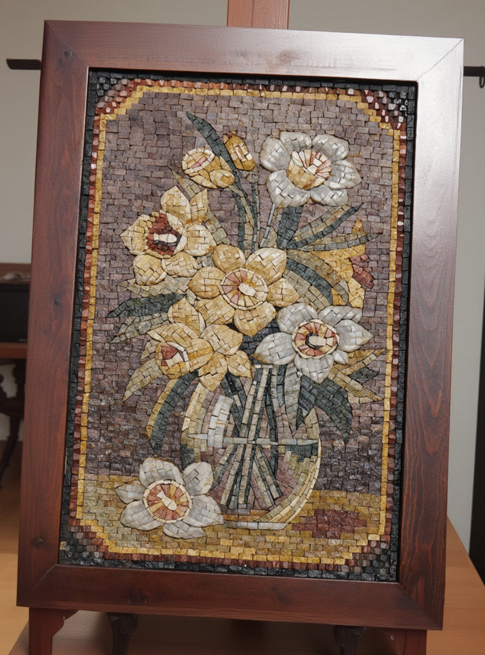 Intricate mosaic wall art featuring a floral arrangement of yellow and white daffodils in a textured wooden frame — vibrant colors enhance the craftsmanship.